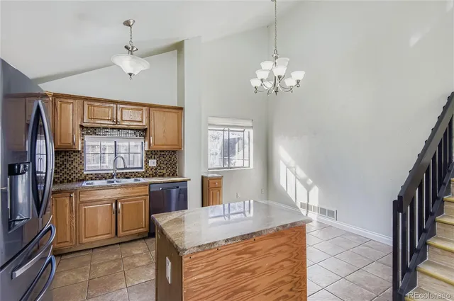 a kitchen with stainless steel appliances granite countertop a refrigerator oven a sink dishwasher and white cabinets with wooden floor