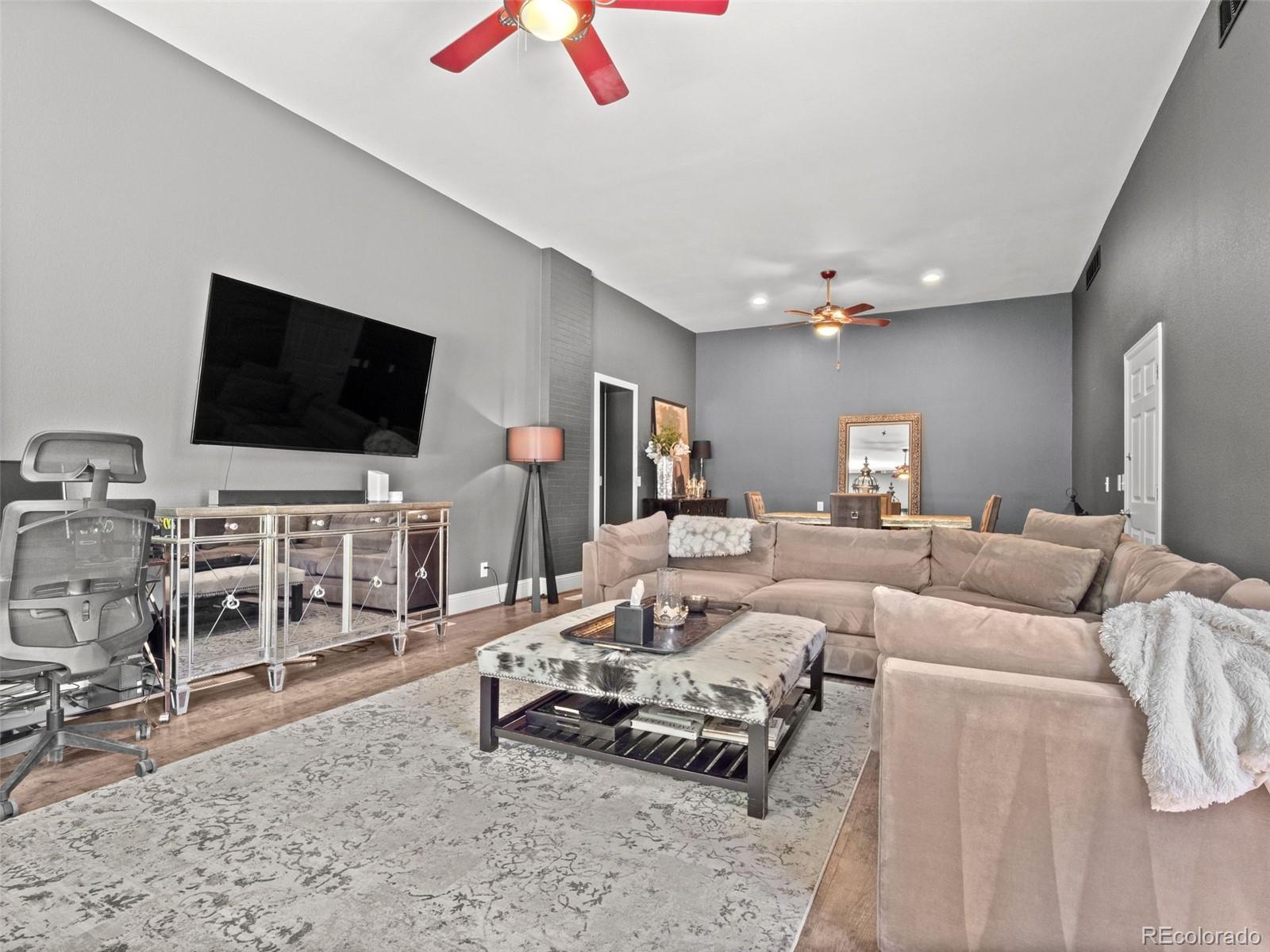 6595 West 46th Place Wheat Ridge, CO 80033 - Photo 11 of 48 a living room with furniture and a flat screen tv