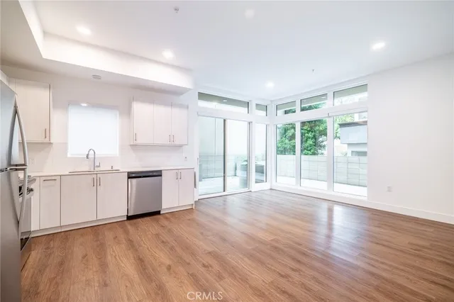 a large white kitchen with wooden floors and white walls