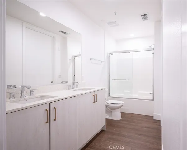 a bathroom with a toilet a sink and a large mirror