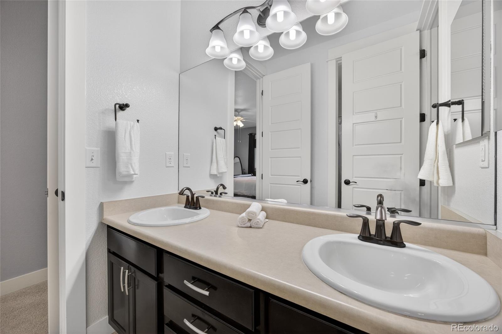 20554 East Shady Ridge Road Parker, CO 80134 - Photo 30 of 49 a bathroom with a double vanity sink and a mirror
