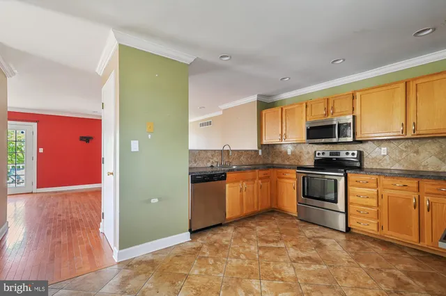a kitchen with granite countertop a stove top oven a sink a counter space and cabinets