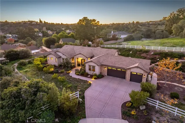 an aerial view of a house with a garden and lake view