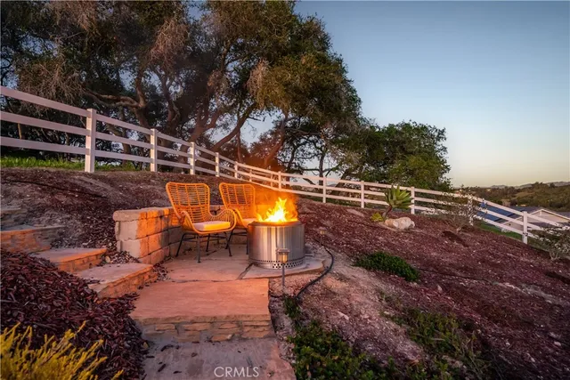 a view of a house with a big yard plants and large tree