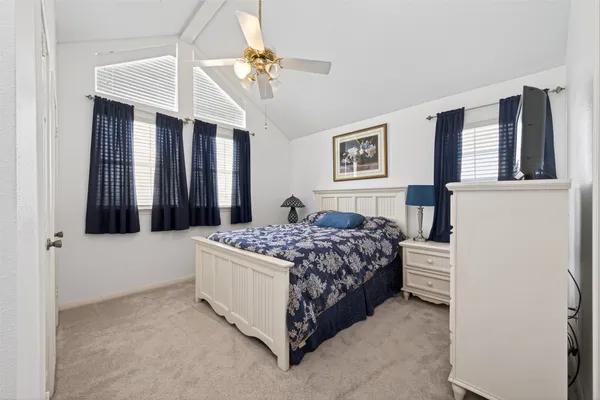 a bedroom with a bed lamp and a window