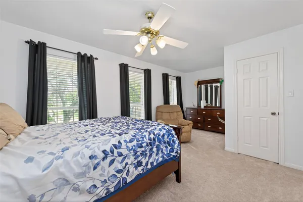 a bedroom with a bed chandelier and a window