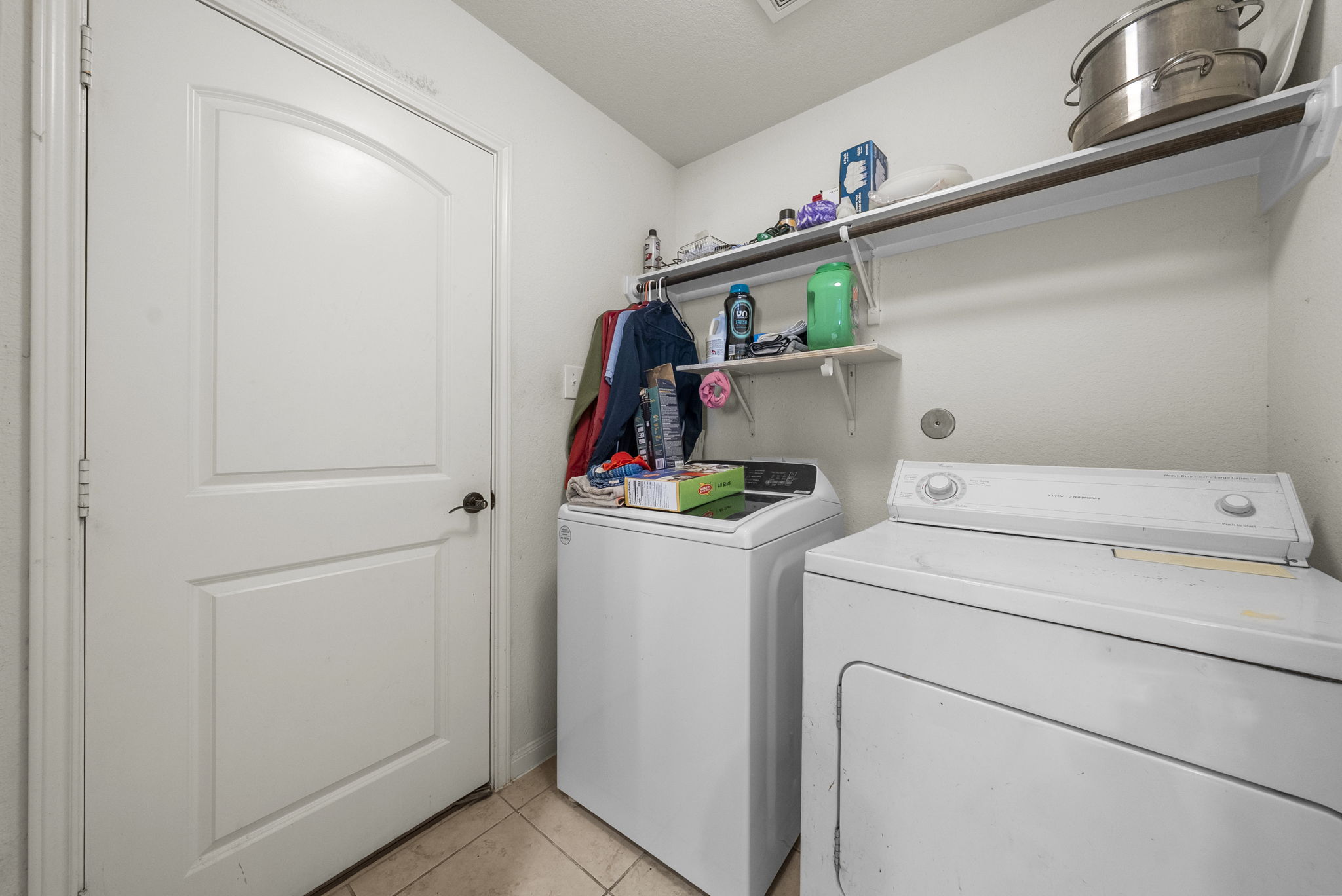 1617 Treeta Trail Kyle, TX 78640 - Photo 37 of 39 Laundry room with washing machine and clothes dryer and light tile patterned floors