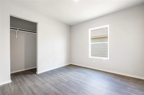 an empty room with wooden floor and a window