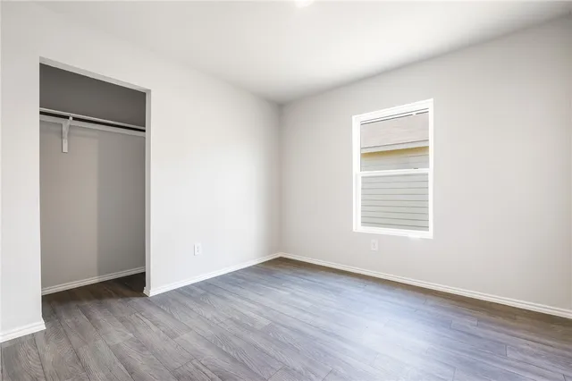 an empty room with wooden floor and a window