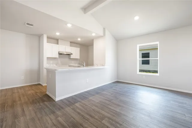 a view of large kitchen with wooden floor and windows