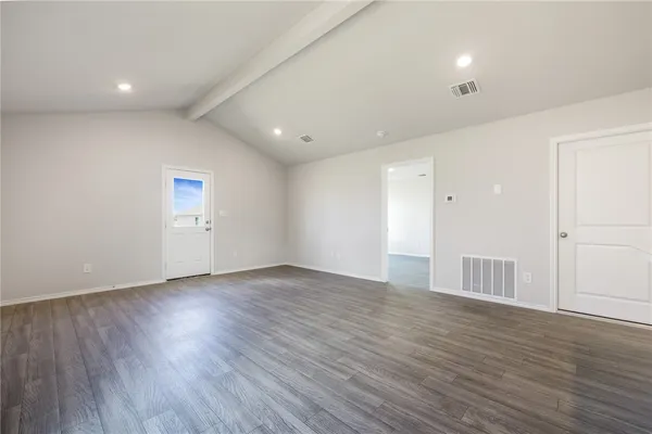 a view of an empty room with wooden floor