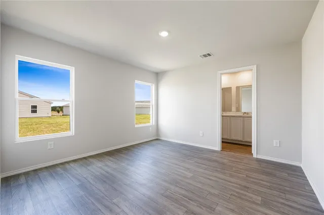 an empty room with wooden floor and a window