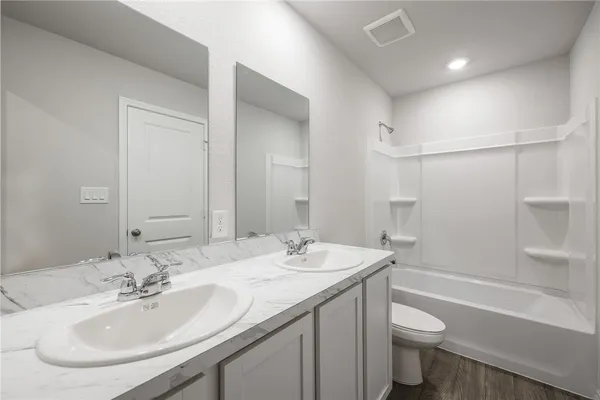 a bathroom with a sink double vanity granite toilet tub and shower