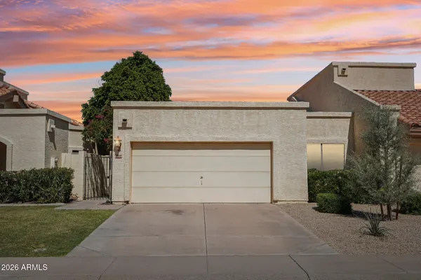 front view of a house with a yard and a garage