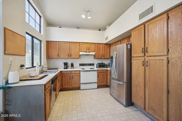 a kitchen with stainless steel appliances granite countertop a refrigerator sink and stove