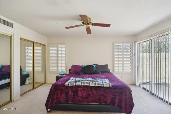 a bedroom with a bed and a ceiling fan