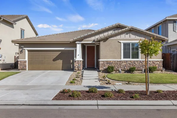 a front view of a house with a yard and garage