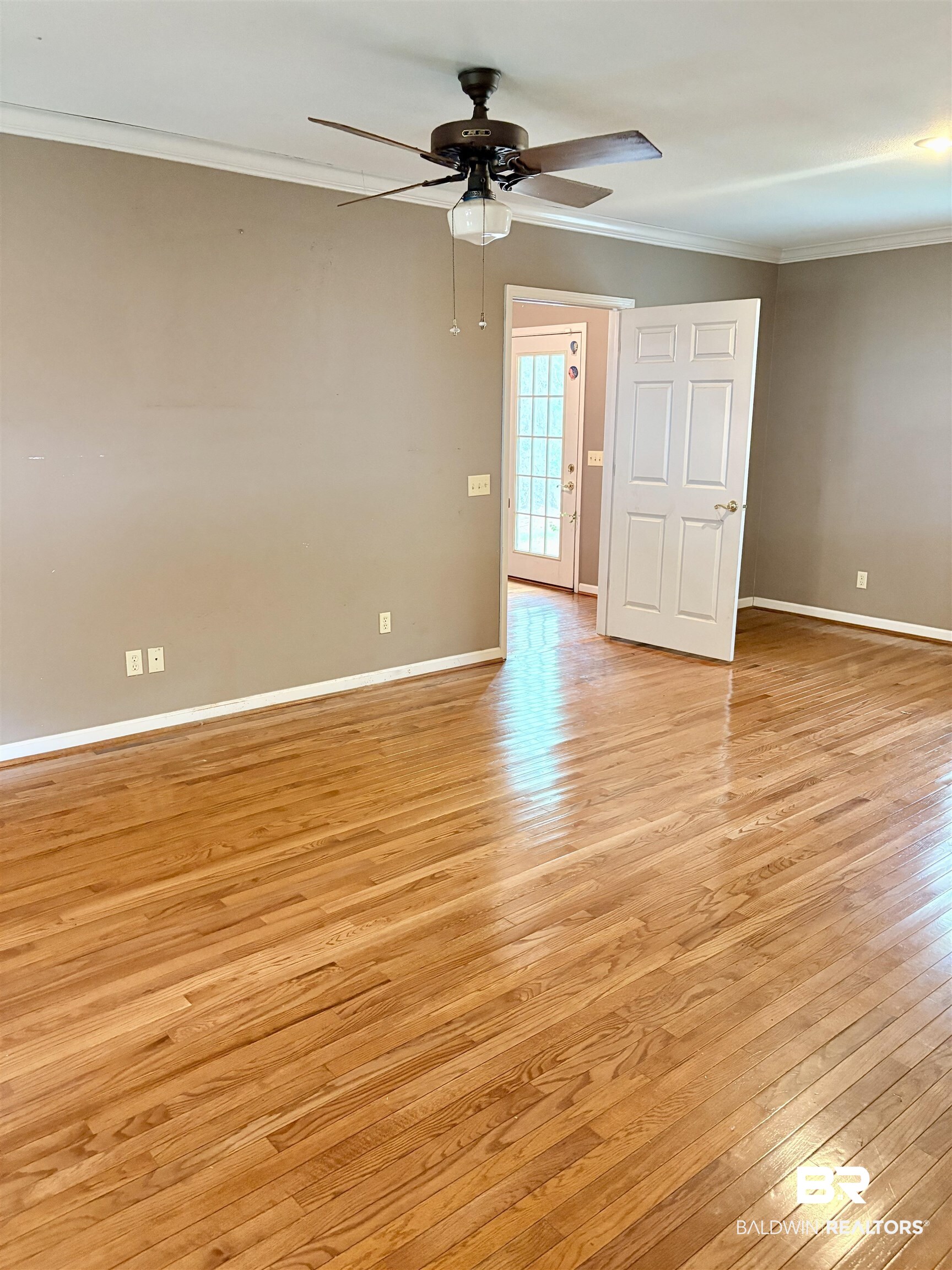 1018 Bates Road Evergreen, AL 36401 - Photo 11 of 21 Unfurnished room featuring light wood-style flooring, ornamental molding, and ceiling fan