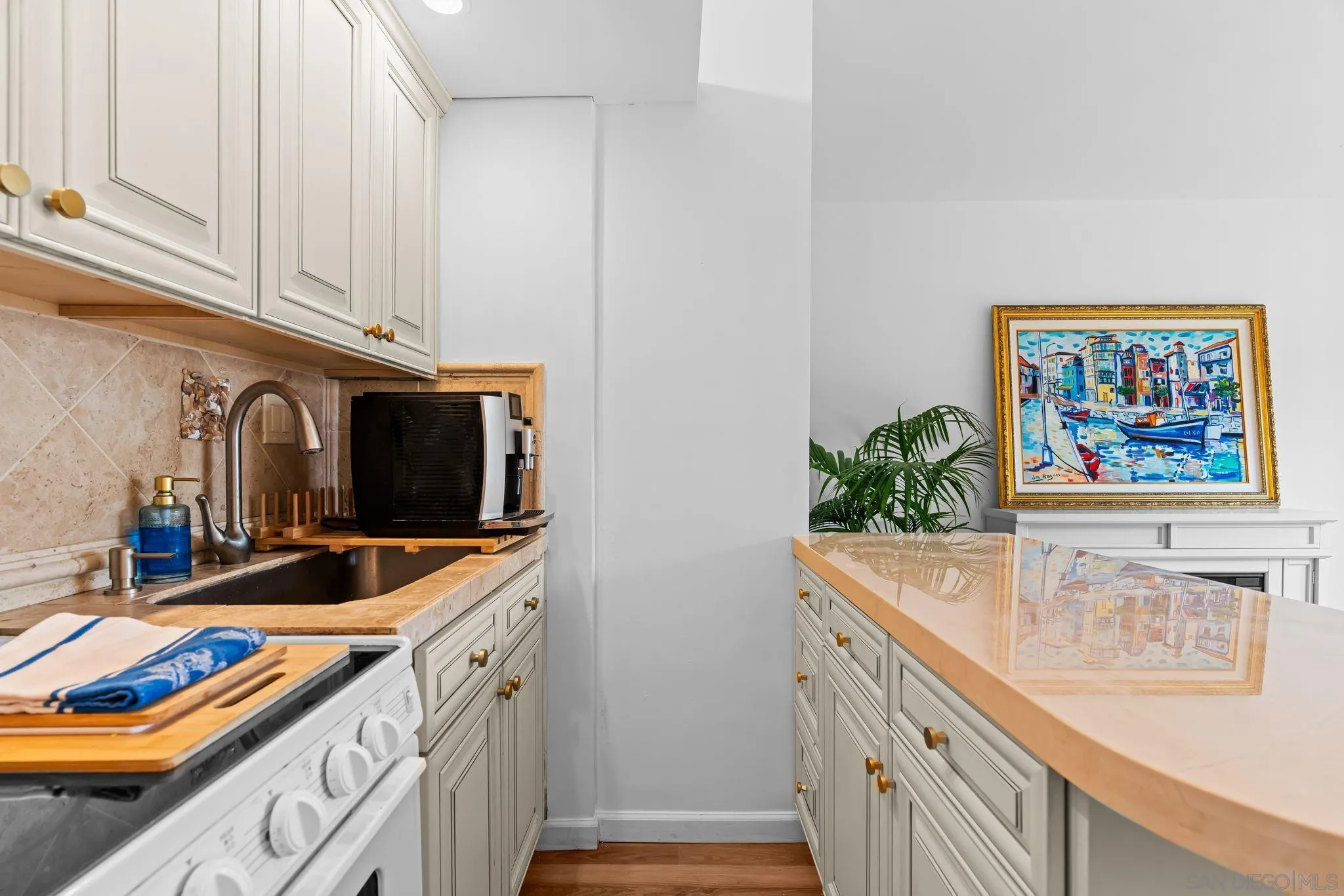 230 Prospect Street, Unit 12 La Jolla, CA 92037 - Photo 8 of 14 a kitchen with stainless steel appliances granite countertop a sink and a microwave