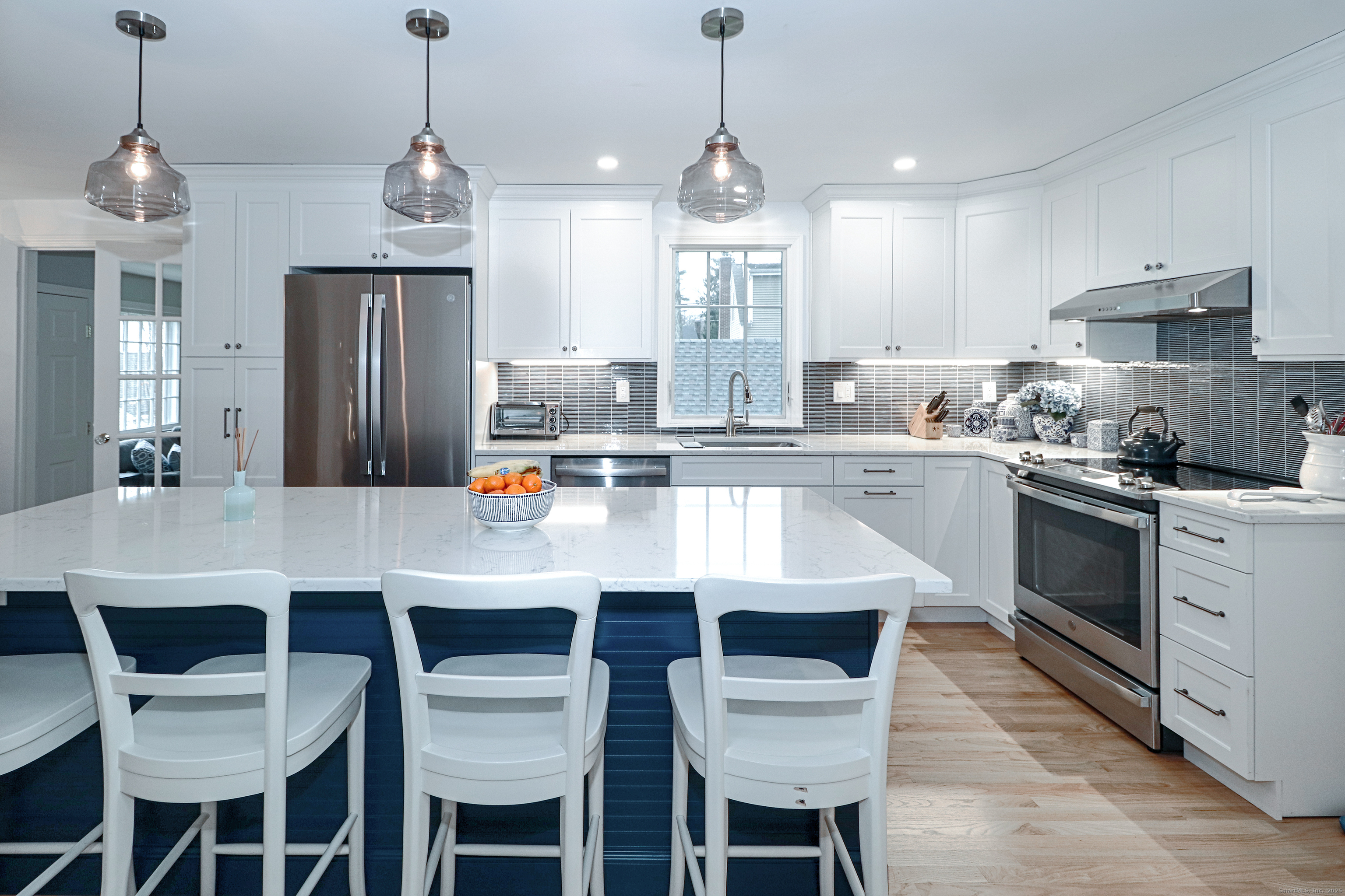 30 Falmouth Road Fairfield, CT 06825 - Photo 13 of 37 a kitchen with stainless steel appliances granite countertop a sink a stove a refrigerator cabinets and chairs