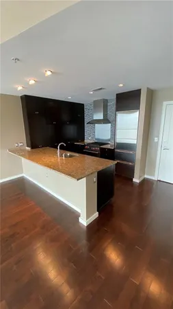 a kitchen with granite countertop a sink and a stove top oven