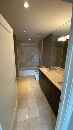 a bathroom with a glass door shower a sink and a mirror