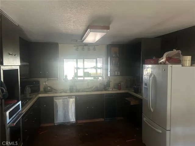 a kitchen with metallic refrigerator and sink