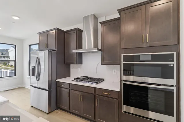 a kitchen with stainless steel appliances granite countertop a refrigerator and a stove top oven