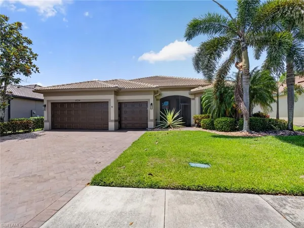 a front view of a house with a garden and palm trees