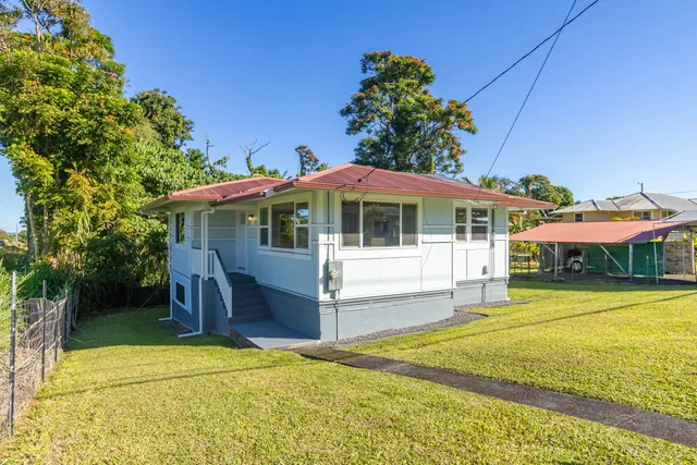 a front view of a house with a yard table and chairs