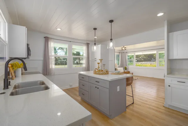 a kitchen with a stove a sink a counter space and a window