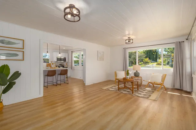 a view of a dining room with furniture a chandelier and wooden floor