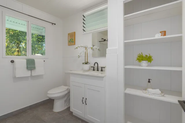 a spacious bathroom with a sink a toilet and a mirror
