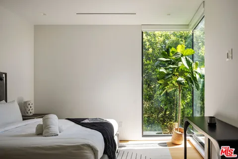 a bedroom with a bed and a potted plant
