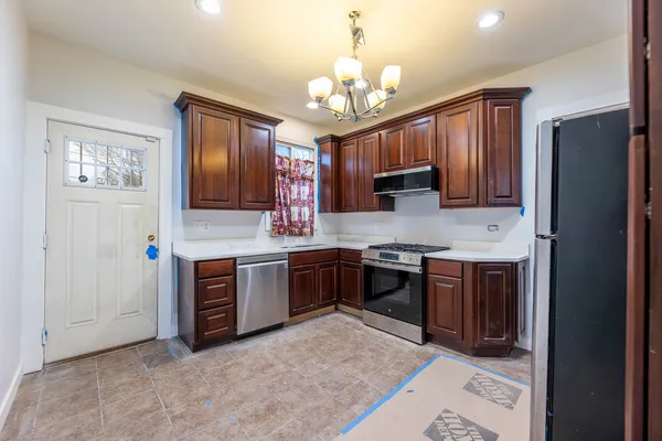 a kitchen with stainless steel appliances granite countertop a stove refrigerator sink and cabinets