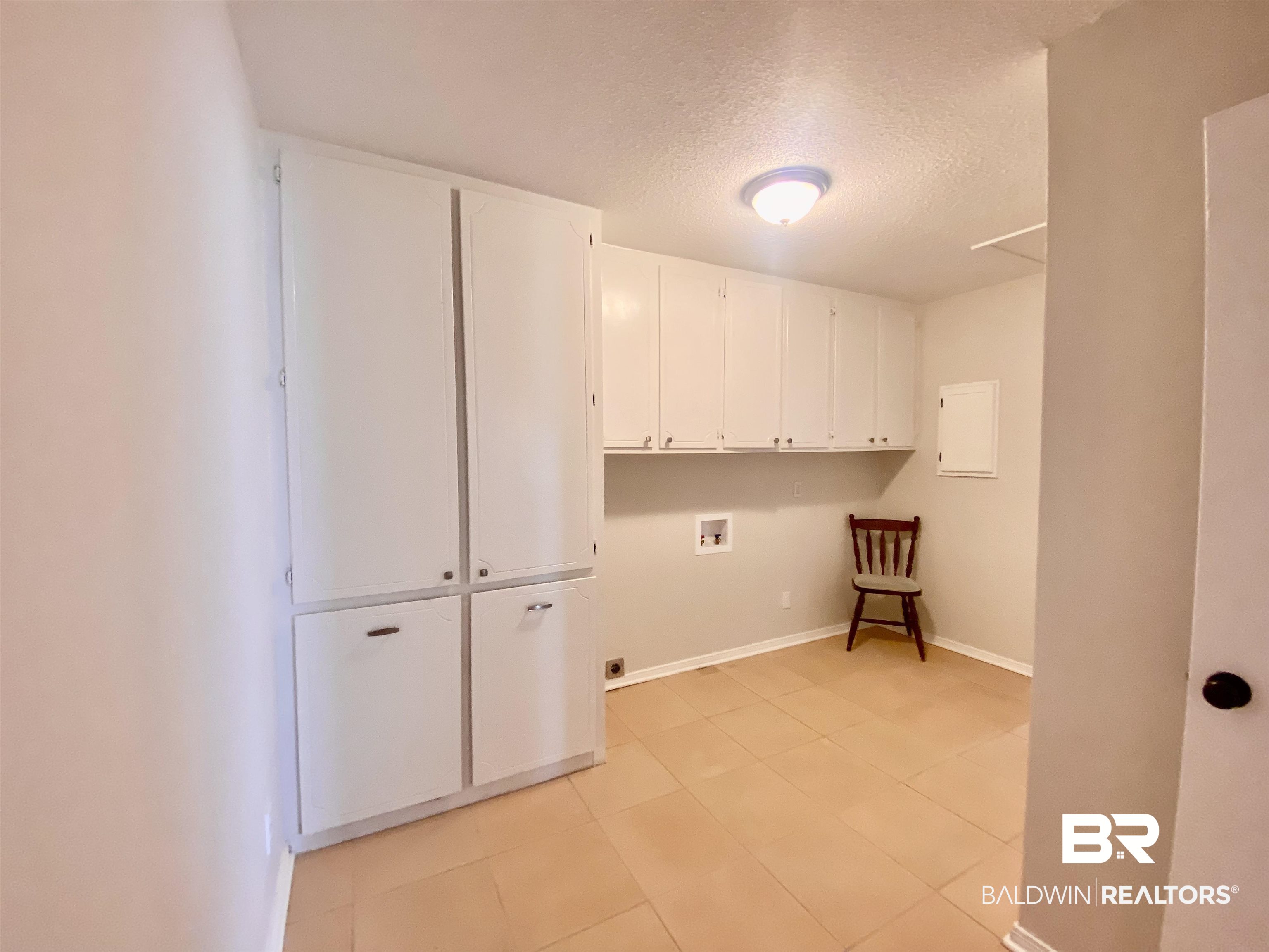 265 Azalea Drive Monroeville, AL 36460 - Photo 19 of 39 Laundry room with cabinets, washer hookup, a textured ceiling, light tile patterned floors, and electric dryer hookup