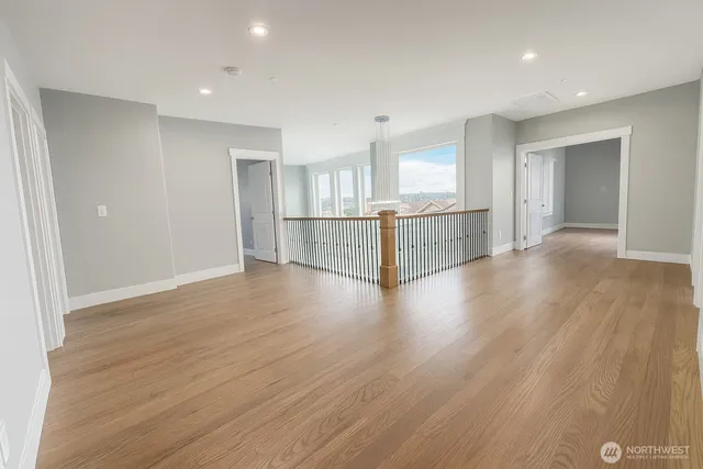 an empty room with wooden floor and window