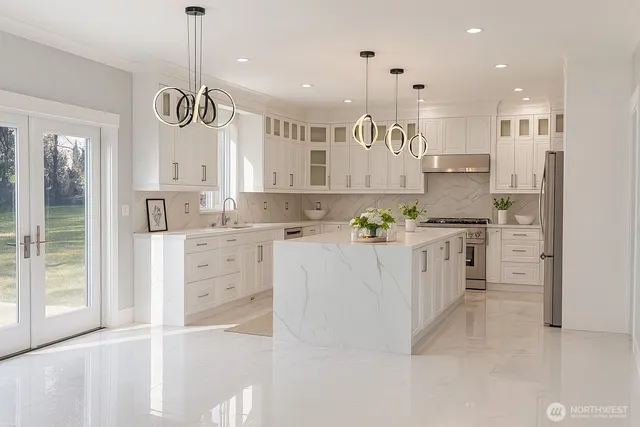 a large kitchen with kitchen island white cabinets and stainless steel appliances