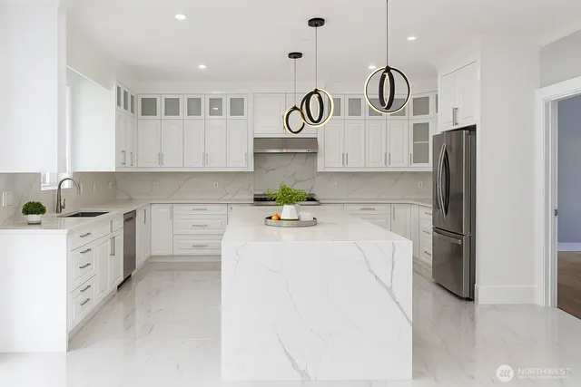 a kitchen with stainless steel appliances a refrigerator sink and white cabinets