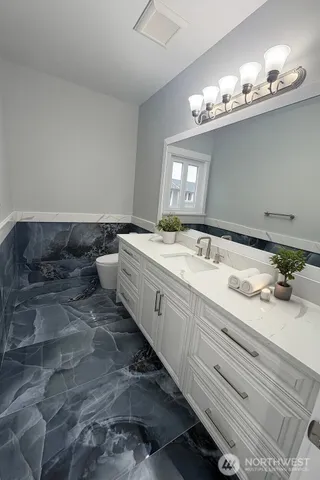 a spacious bathroom with double vanity and a mirror