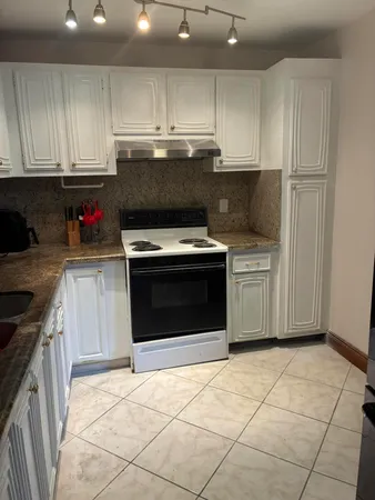 a kitchen with a stove top oven and cabinets
