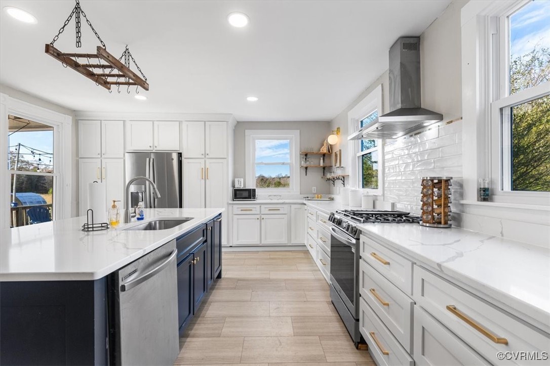Kitchen featuring sink, white cabinets, wall chimn