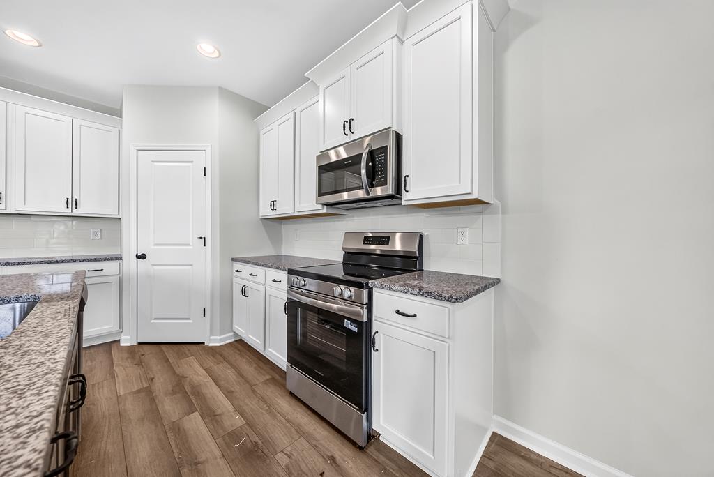 6 Liberty Place Fort Mitchell, AL 36856 - Photo 10 of 27 a kitchen with stainless steel appliances granite countertop a stove a sink and a microwave