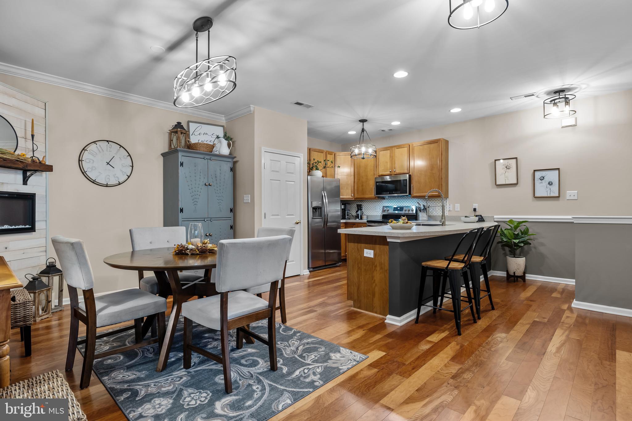 265 Covenant Lane, Unit 8 Harleysville, PA 19438 - Photo 3 of 21 a kitchen with stainless steel appliances kitchen island granite countertop a table chairs sink and cabinets