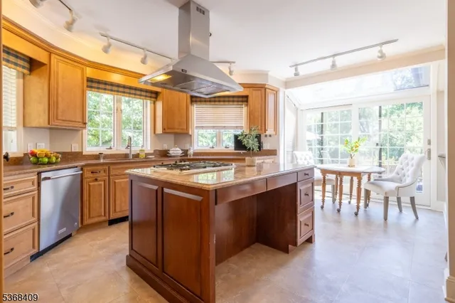 a kitchen with kitchen island granite countertop a sink stove and cabinets