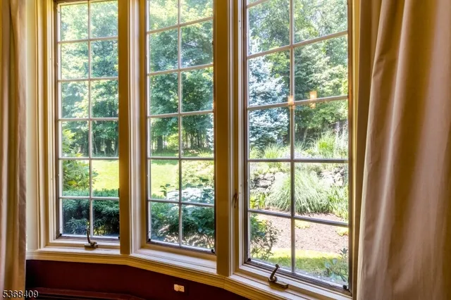 a view of a room with a large window and wooden floor