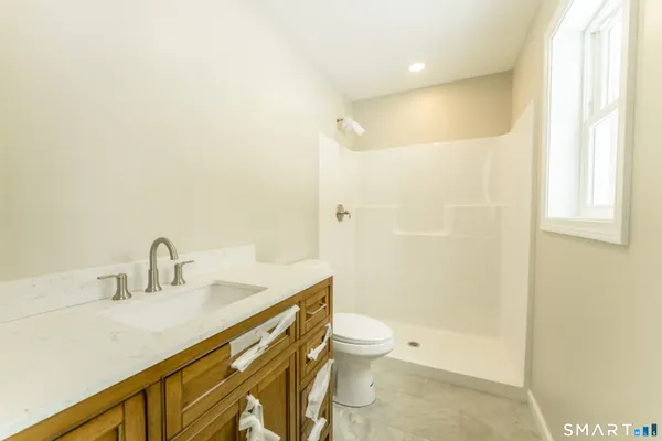 a bathroom with a sink a toilet and shower