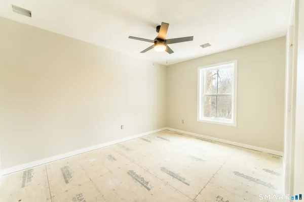 an empty room with a window and a ceiling fan