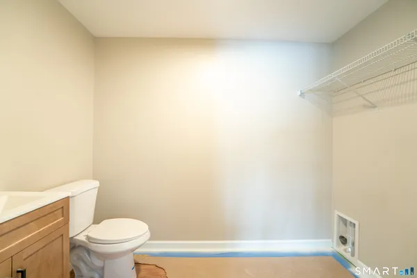 a white toilet sitting next to a white wall
