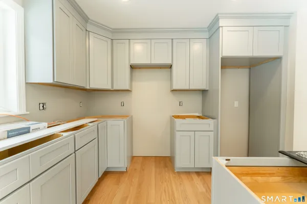 a kitchen with cabinets and wooden floor